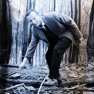 Man in suit walking through a flooded forest area.