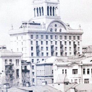 Black and white cityscape with a grand building in the distance.