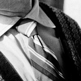 Black and white portrait of a man in a vest.