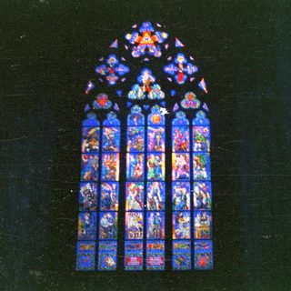 Detailed stained glass window depicting religious figures and scenes.