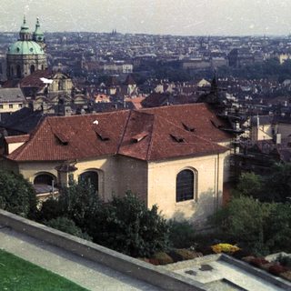 Prague cityscape featuring a church and rooftops.
