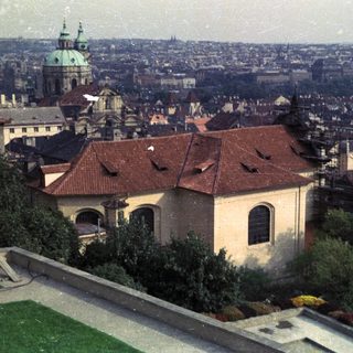 Prague cityscape featuring a church and rooftops.