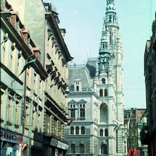 Street view of a tall building and people walking.
