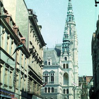 Street view of a tall building and people walking.