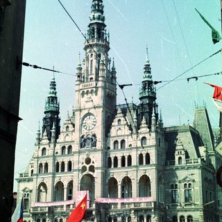 Grand, ornate building with flags and a clock tower.
