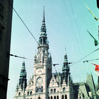 Grand, ornate building with flags and a clock tower.
