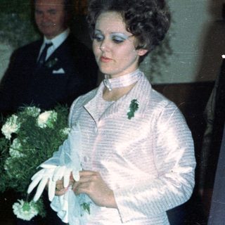 Couple in formal wear with attendants, likely at a wedding.