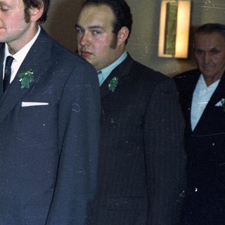 Couple in formal wear with attendants, likely at a wedding.