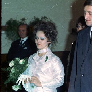 Couple in formal wear with attendants, likely at a wedding.