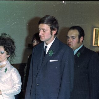 Couple in formal wear with attendants, likely at a wedding.