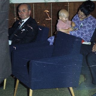 Family seated in chairs, possibly at an event.