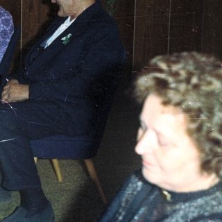 Family seated in chairs, possibly at an event.