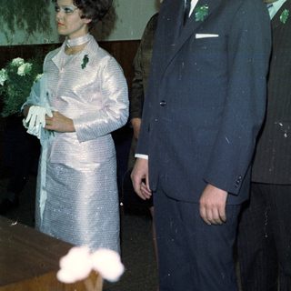 Here's a brief summary of the image: Formal portrait of three people, possibly at a wedding.