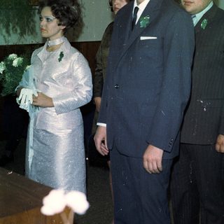 Here's a brief summary of the image: Formal portrait of three people, possibly at a wedding.