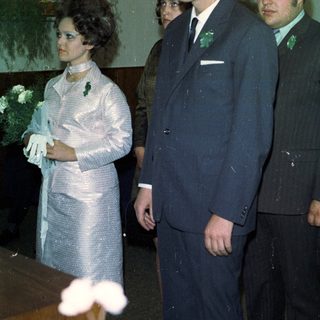 Here's a brief summary of the image: Formal portrait of three people, possibly at a wedding.