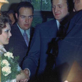 Couple with guests at a formal event, likely a wedding.