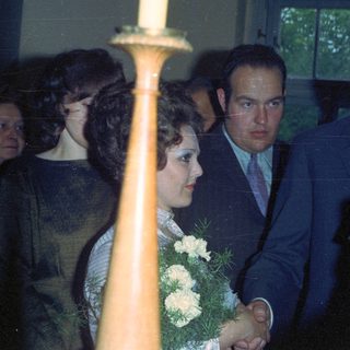 Couple with guests at a formal event, likely a wedding.