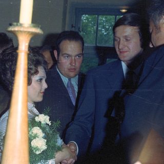 Couple with guests at a formal event, likely a wedding.