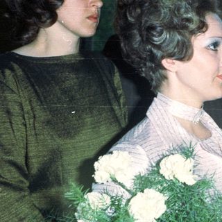Bride with guests and a man holding a notepad.