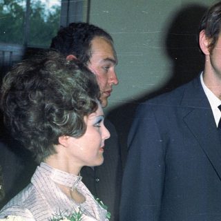 Three people in suits near a window.