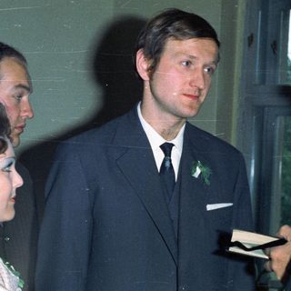Three people in suits near a window.