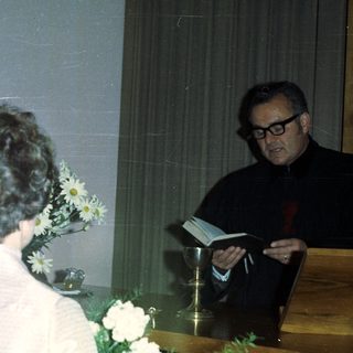Couple being married by a priest in a church.