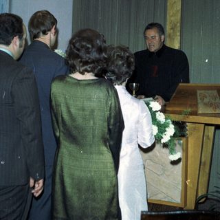 Here's a brief summary of the image: People participate in a religious ceremony near a cross.