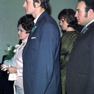 Couple and two men walking side-by-side, likely at an event.