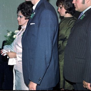 Couple and two men walking side-by-side, likely at an event.