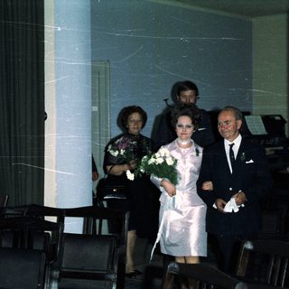 Couple walking down an aisle during a wedding ceremony.