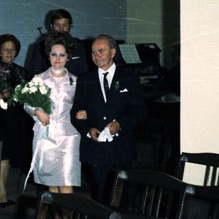 Couple walking down an aisle during a wedding ceremony.