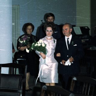 Couple walking down an aisle during a wedding ceremony.