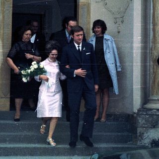 Couple exiting a building, possibly a wedding or formal event.