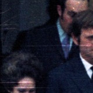 Couple exiting a building, possibly a wedding or formal event.