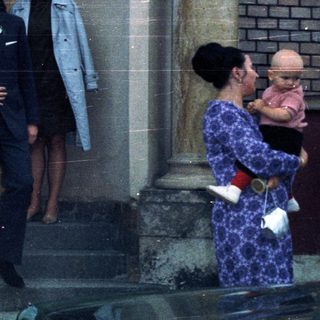 Couple exiting a building, possibly a wedding or formal event.
