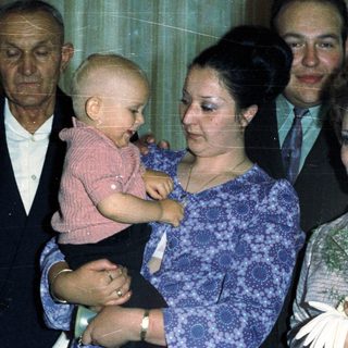Family portrait with a baby, likely a wedding or celebration.