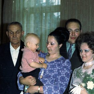 Family portrait with a baby, likely a wedding or celebration.