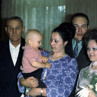 Family portrait with a baby, likely a wedding or celebration.