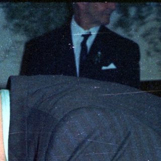 Man signing document, possibly at a formal event.