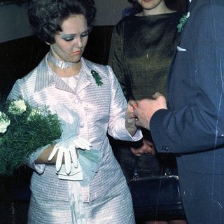 Couple exchanging rings, likely during a wedding ceremony.