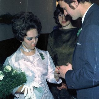 Couple exchanging rings, likely during a wedding ceremony.