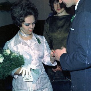 Couple exchanging rings, likely during a wedding ceremony.