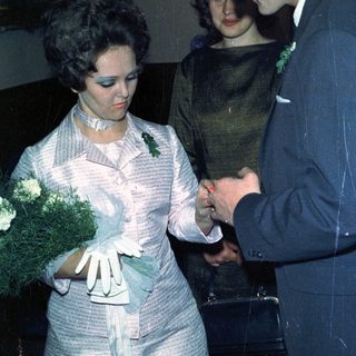 Couple exchanging rings, likely during a wedding ceremony.