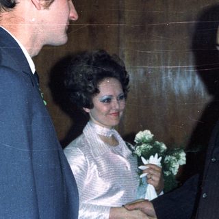 Men conversing with a woman in a wedding dress.