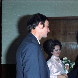 Men conversing with a woman in a wedding dress.