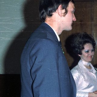 Men conversing with a woman in a wedding dress.
