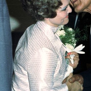 Man embraces a woman in a formal setting.