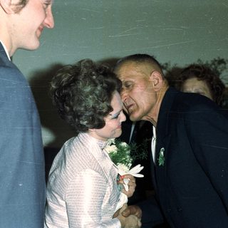 Man embraces a woman in a formal setting.