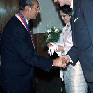 Man awards a newly married couple with an honor.