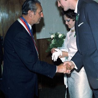 Man awards a newly married couple with an honor.